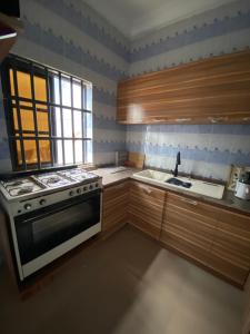 a kitchen with a stove and a sink at Le cozy in Abomey-Calavi