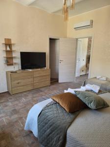 a bedroom with two beds and a flat screen tv at Risorta Ponente in Boiano