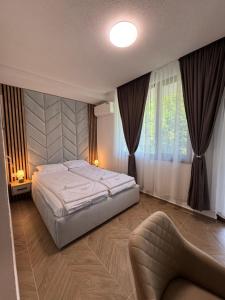 a bedroom with a large bed and a chair at Комплекс Ванката in Kamena