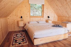 a bedroom with a bed in a wooden cabin at Strefa ciszy Lubomin in Lubomin