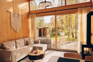 a living room with a couch and a large window at Strefa ciszy Lubomin in Lubomin