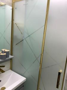 Eine Dusche mit Glastür neben einem Waschbecken in der Unterkunft Террас 5 in Astara