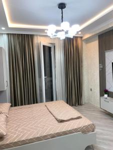 ein Schlafzimmer mit einem Bett und einem Kronleuchter in der Unterkunft Террас 5 in Astara