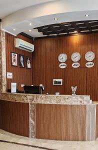 a lobby with a counter with clocks on the wall at المها إن للشقق المخدومة in Hail