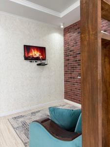a living room with a fireplace and a tv on the wall at Asia Street in Bishkek