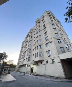 a tall white building with windows on a street at Asia Street in Bishkek