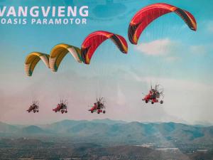 a group of paratroopers flying in the sky at BON Premier Boutique Hotel in Vang Vieng