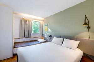 a bedroom with a large white bed and a window at ibis Nancy-Brabois in Vandoeuvre-lès-Nancy +154 photos