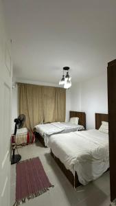 a bedroom with two beds and a lamp in it at Blumar El Sokhna in Ain Sokhna