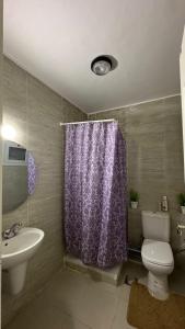 a bathroom with a purple shower curtain and a toilet at Blumar El Sokhna in Ain Sokhna +24 photos