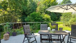 a table and chairs with an umbrella on a patio at Ferienhaus Triebesgrund in Zeulenroda