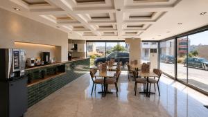 a dining room with tables and chairs and windows at Nora Airport Hotel in Arnavutköy