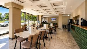 a restaurant with tables and chairs and a counter at Nora Airport Hotel in Arnavutköy