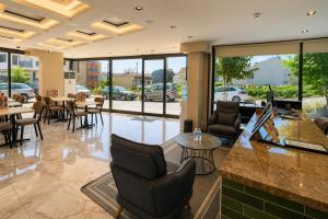 a lobby with chairs and tables in a building at Nora Airport Hotel in Arnavutköy