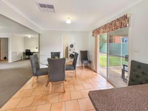 a living room with a table and chairs at Suburban Bliss - Elegant Villa 2 in Wagga Wagga