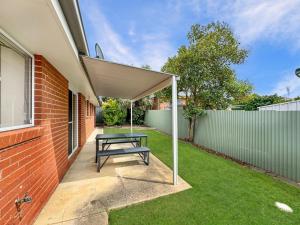 a patio with a picnic table under awning at Suburban Bliss - Elegant Villa 2 in Wagga Wagga