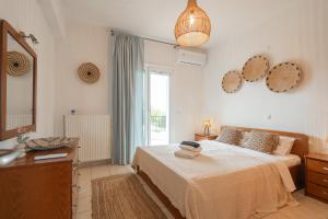 a bedroom with a bed and a sink and a mirror at Sunset Villa Amelia Skiathos in Skiathos National Airport +35 photos