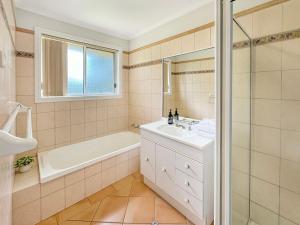 a bathroom with a tub and a sink and a shower at Suburban Bliss - Elegant Villa 2 in Wagga Wagga +16 photos