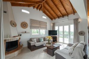 a living room with a couch and a fireplace at Sunset Villa Amelia Skiathos in Skiathos National Airport