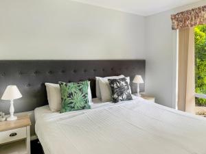 a bedroom with a large white bed with green pillows at Suburban Bliss - Elegant Villa 2 in Wagga Wagga