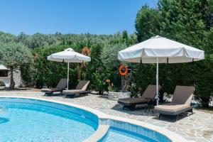 a swimming pool with two umbrellas and chairs and a swimming pool at Sunset Villa Amelia Skiathos in Skiathos National Airport