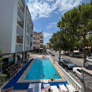 a swimming pool in the middle of a building with people in it at Yağmur Apart Otel in Didim
