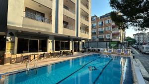 a large swimming pool in front of a building at Yağmur Apart Otel in Didim