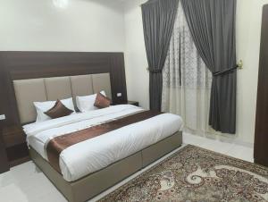 a bedroom with a large bed and a window at العييري للشقق المخدومة in Dammam