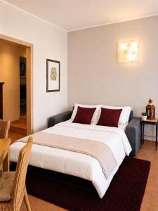 a bedroom with a large white bed with red pillows at Casa Artis in Gravedona +54 photos