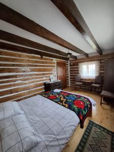 a bedroom with a large bed in a room at Căsuța Anei in Rîmeţi-Valea Inzelului