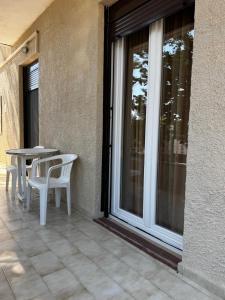 eine Terrasse mit Tisch und Stühlen neben einem Fenster in der Unterkunft Karfas Hideaway in Karfás + 4 Fotos