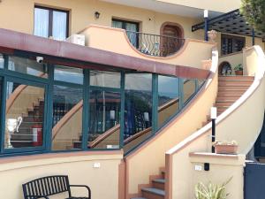 a house with a curved staircase and a bench at My Sicily apartments in Taormina +7 photos