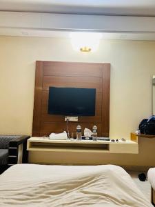 a hotel room with a bed and a flat screen tv at Hotel Ovisar in Cox's Bazar