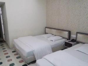 a room with two beds in a hotel room at Hotel Ovisar in Cox's Bazar