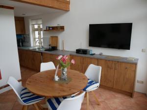 a dining room with a table with chairs and a tv at Sonnendeck in Wustrow