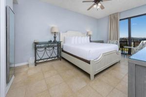 a white bedroom with a bed and a balcony at Phoenix X 101 in Orange Beach