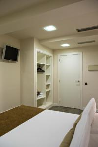 a bedroom with a bed and a closet at BCN Urbaness Hotels Del Comte in Barcelona