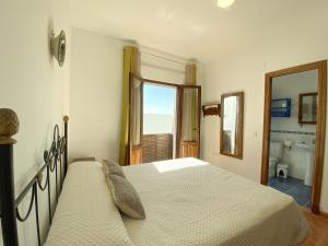 a bedroom with a bed and a bathroom at 1 linea de playa - Apartamentos - Beach & River - Conil in Conil de la Frontera