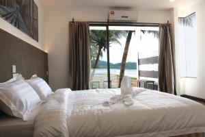ein Schlafzimmer mit einem Bett mit Blick auf das Meer in der Unterkunft The Barat Tioman Beach Resort in Kampong Juara