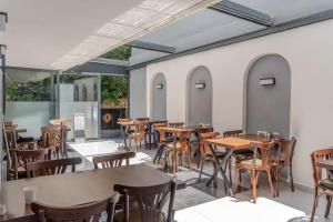an empty restaurant with wooden tables and chairs at Nergiz Boutique Hotel in Antalya