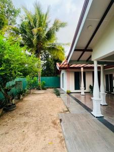 a courtyard of a house with a palm tree at Airport Kiyas Transit Villa Free Airport Pickup or Drop in Katunayaka
