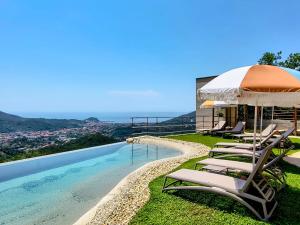 a group of lounge chairs sitting next to a swimming pool at Casa dei Bruschi in Casarza Ligure