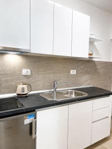 a kitchen with white cabinets and a sink at Apartments Marija Magdalena in Hvar +51 photos
