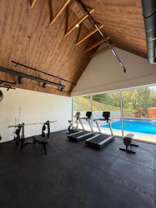 an indoor gym with cardio equipment and a swimming pool at Aura Kaszub Lake&Forest in Łączyno