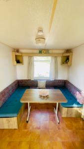 a living room with a table and a couch at Chez Les Garçons Mobile home vintage, confortable avec piscine in Sarlat-la-Canéda