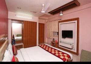 a hotel room with a bed and a flat screen tv at HOTEL LAXMI RESIDENCy in Bikaner