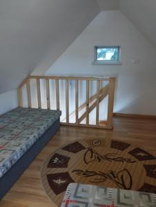 a room with a bed and a staircase with a rug at Domki pod brzózkami in Bodzentyn