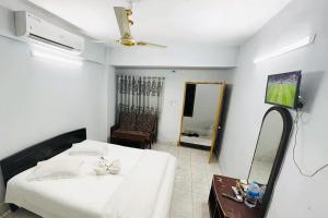 a bedroom with a white bed and a mirror at Rifaee Cox Palace in Cox's Bazar
