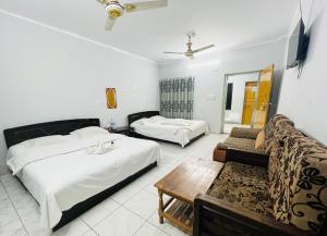 a hotel room with two beds and a couch at Rifaee Cox Palace in Cox's Bazar