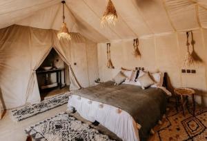 a bedroom with a bed in a tent at Merzouga Luxury Tents & Activities in Merzouga